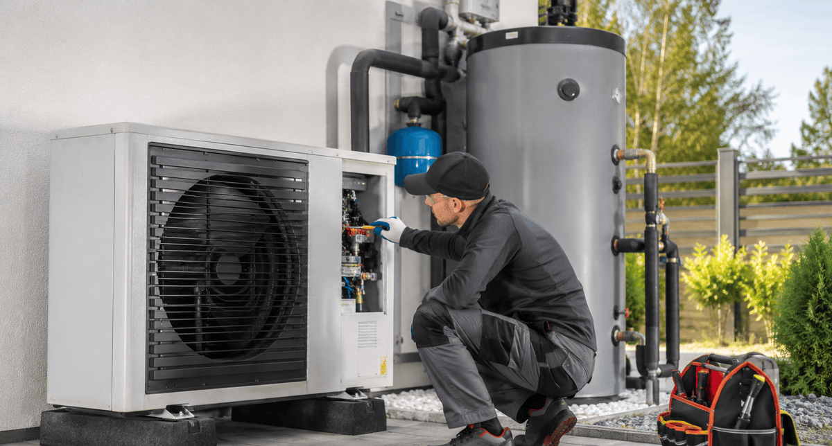 Heat pump maintenance technician servicing a heat pump water heater system for maximum efficiency and long-term performance.